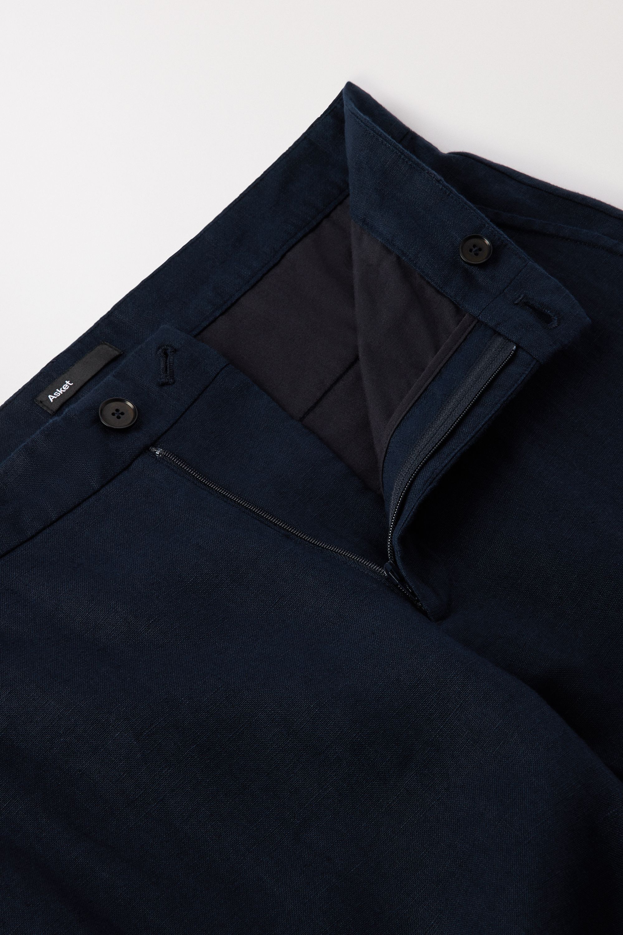 Zip closure with 1 button at the front and 1 button on the inside of the waistband