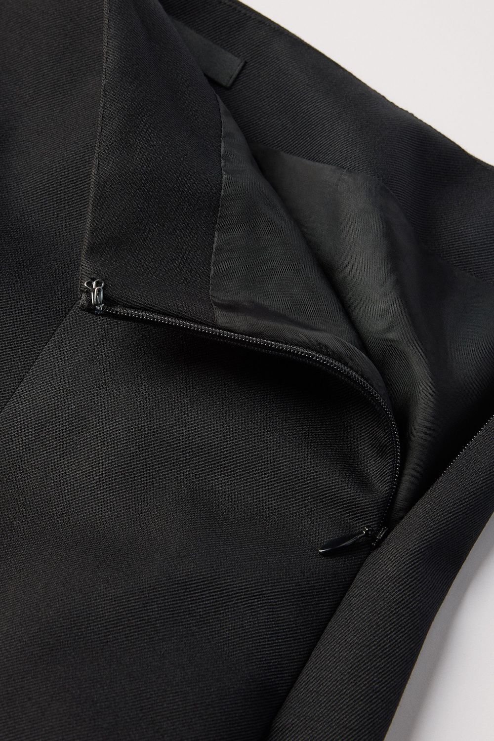 Concealed zip at side seam with hook and eye closure at the top