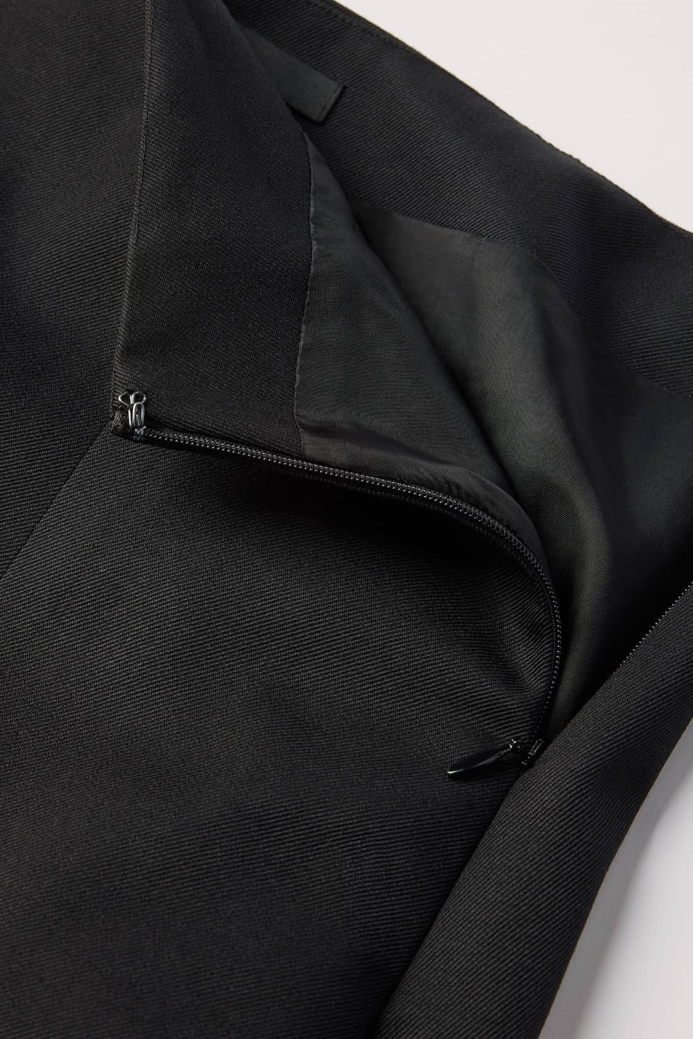 Concealed zip at side seam with hook and eye closure at the top